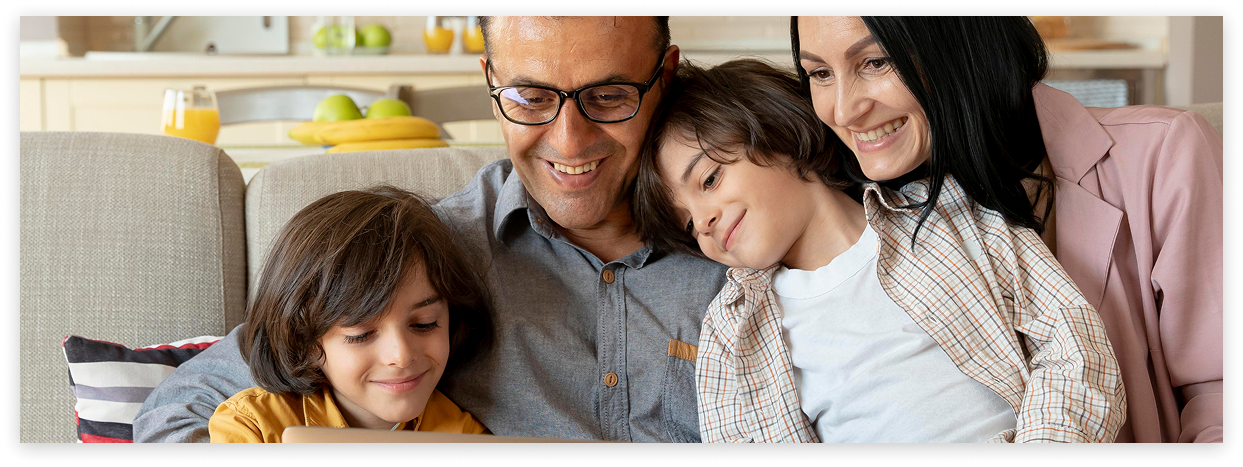 A family sharing a tablet on the sofa